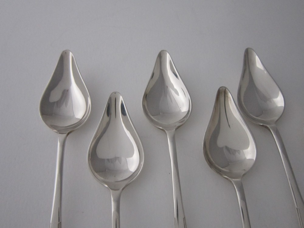 A set of six sterling silver grapefruit spoons with pointed bowls and stepped handles presented inside a fitted black velvet case. View III