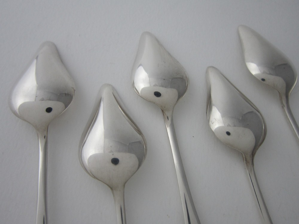 A set of six sterling silver grapefruit spoons with pointed bowls and stepped handles presented inside a fitted black velvet case. View VI