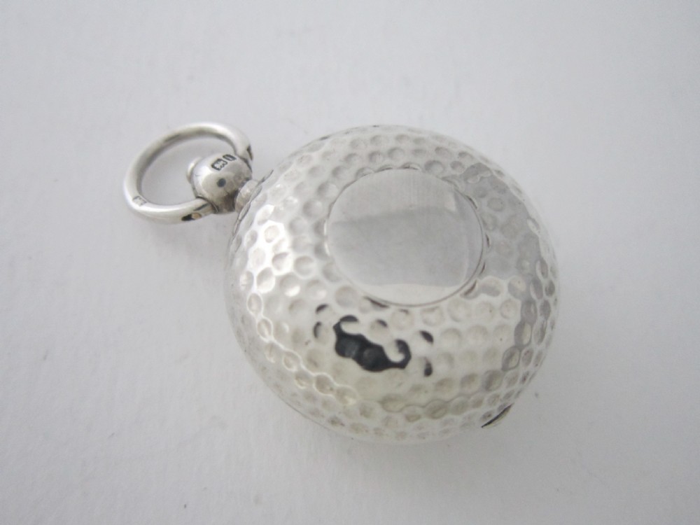 An Edwardian sterling silver sovereign case featuring a dimpled golf ball pattern and a top suspension ring.