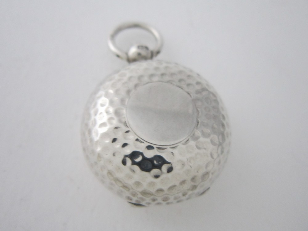 An Edwardian sterling silver sovereign case featuring a dimpled golf ball pattern and a top suspension ring. View II
