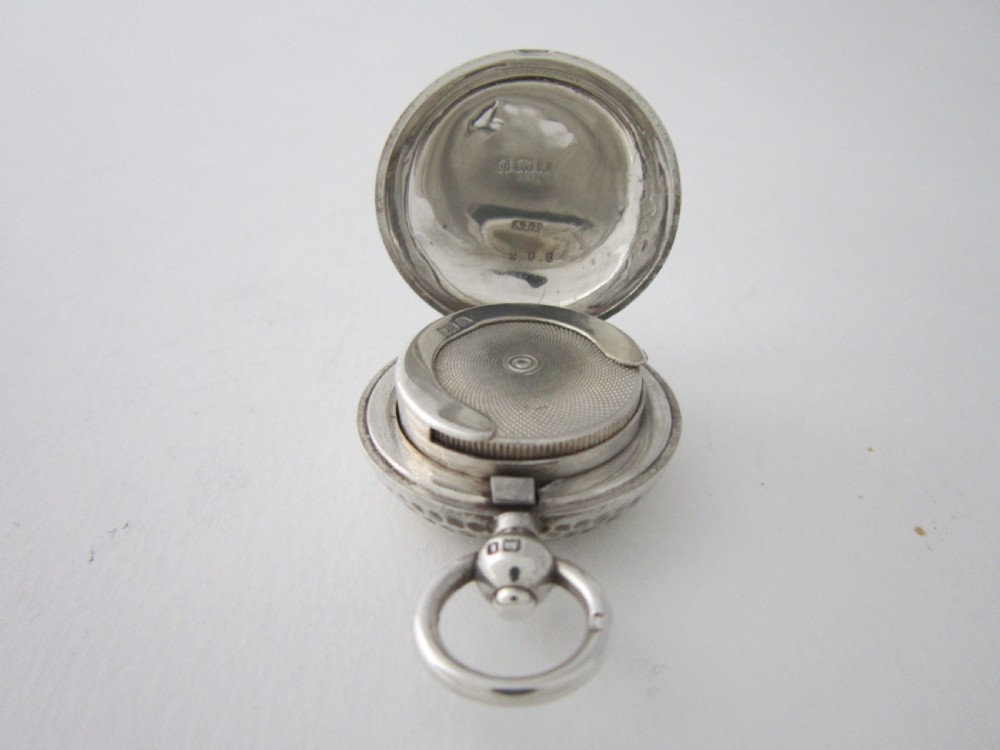An Edwardian sterling silver sovereign case featuring a dimpled golf ball pattern and a top suspension ring. View V