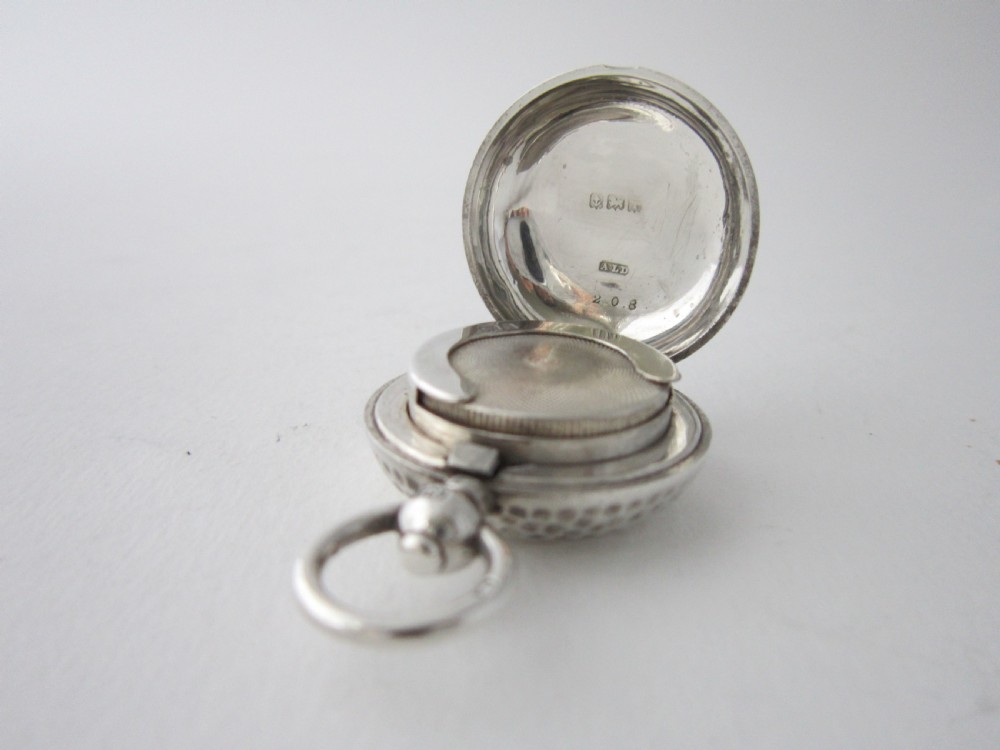 An Edwardian sterling silver sovereign case featuring a dimpled golf ball pattern and a top suspension ring. View VI