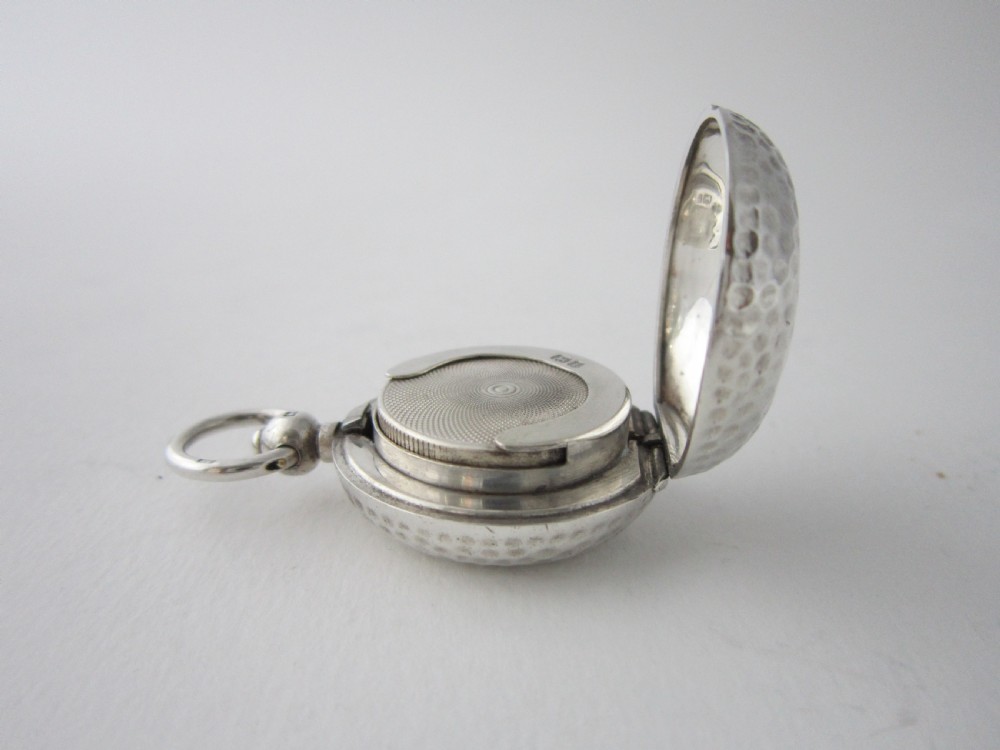 An Edwardian sterling silver sovereign case featuring a dimpled golf ball pattern and a top suspension ring. View VII