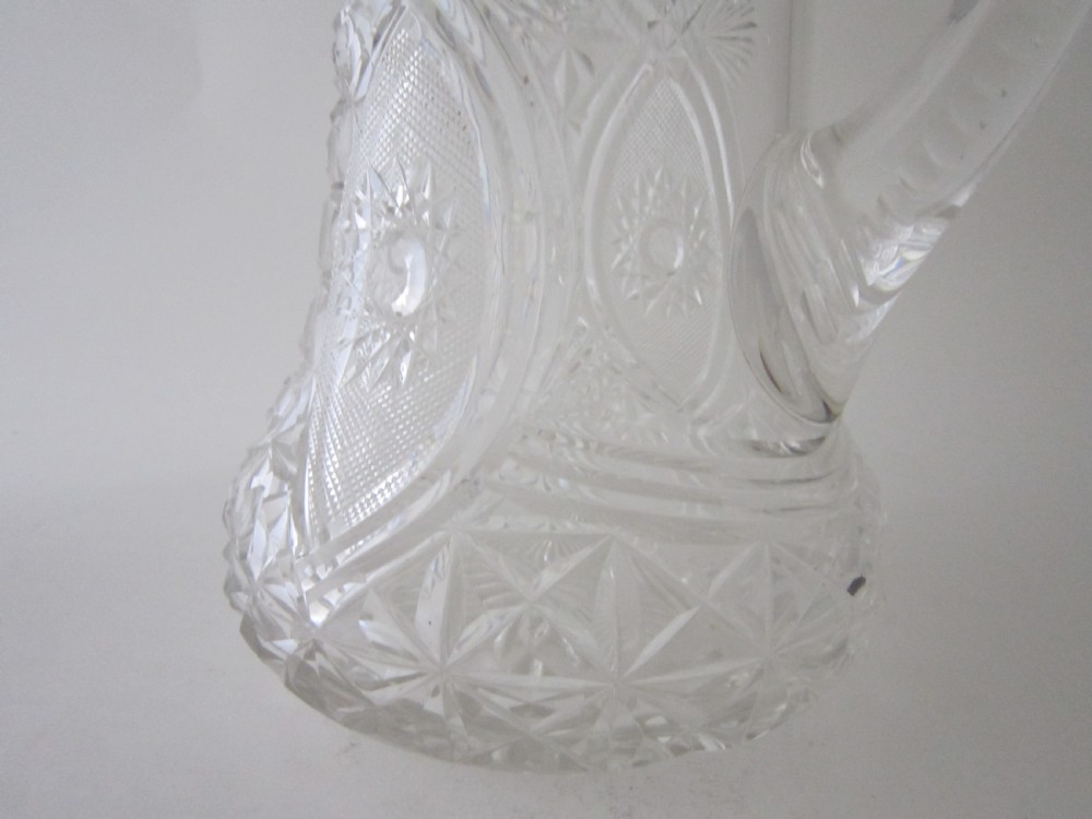 An Edwardian silver-mounted clear cut glass jug featuring geometric diamond carving, a notched glass handle, and a polished sterling silver spout. View V