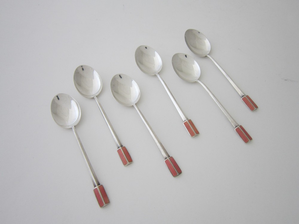 A set of six Art Deco sterling silver coffee spoons with pink enamel terminals presented in an open blue silk-lined case. View III