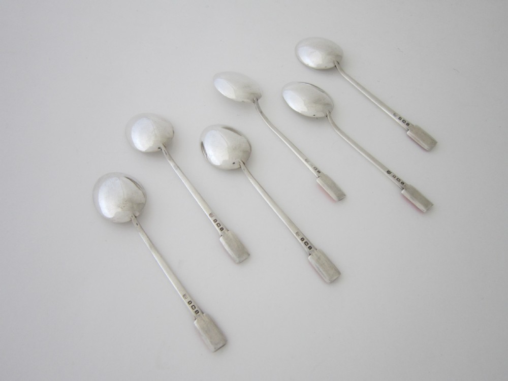 A set of six Art Deco sterling silver coffee spoons with pink enamel terminals presented in an open blue silk-lined case. View IV