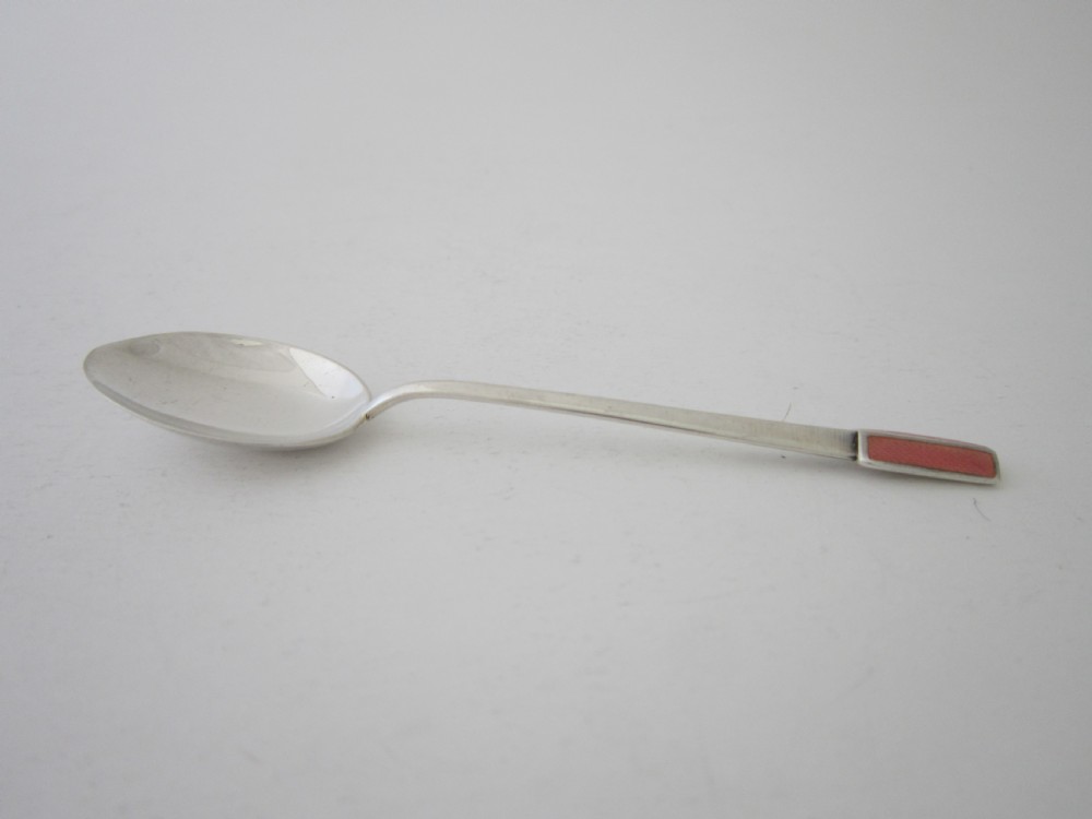 A set of six Art Deco sterling silver coffee spoons with pink enamel terminals presented in an open blue silk-lined case. View VI