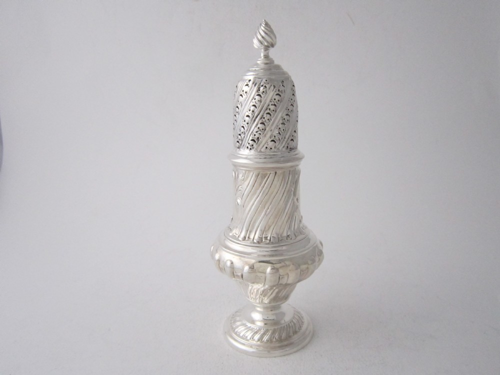 A Victorian sterling silver sugar caster with a spiralled finial, a hand-pierced cap, and a decorated baluster-shaped body. View II