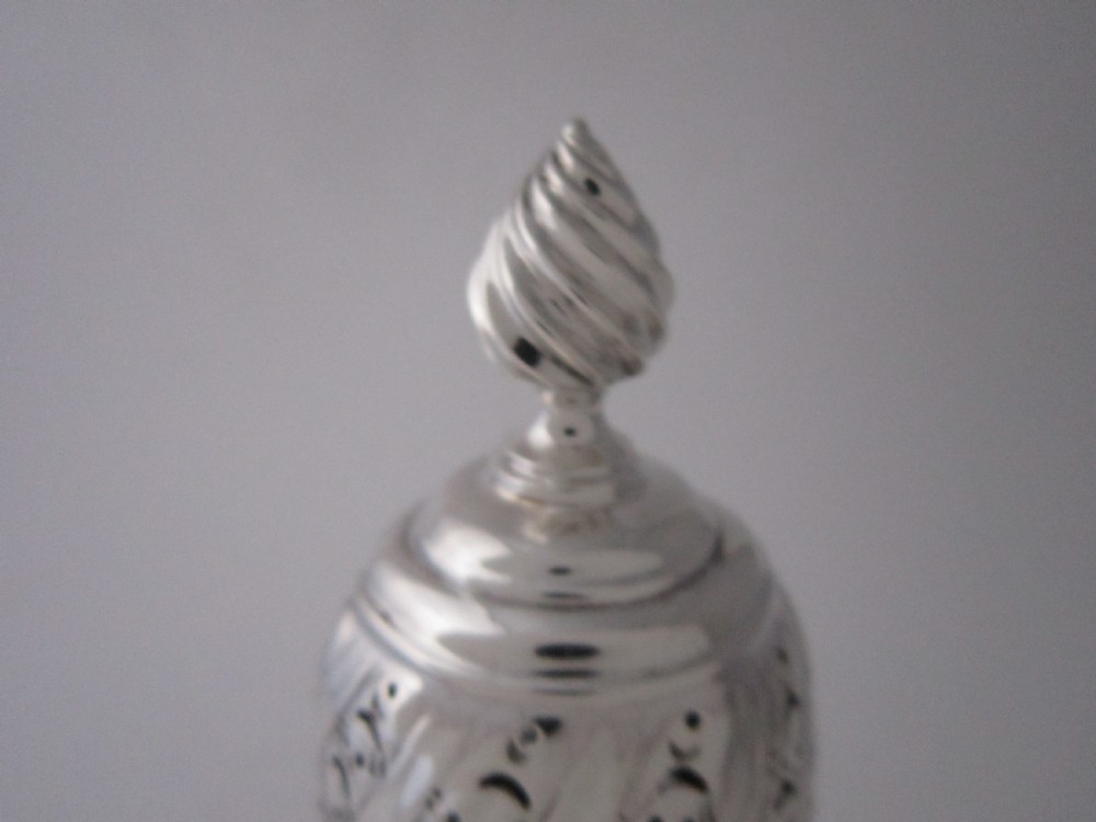 A Victorian sterling silver sugar caster with a spiralled finial, a hand-pierced cap, and a decorated baluster-shaped body. View IV