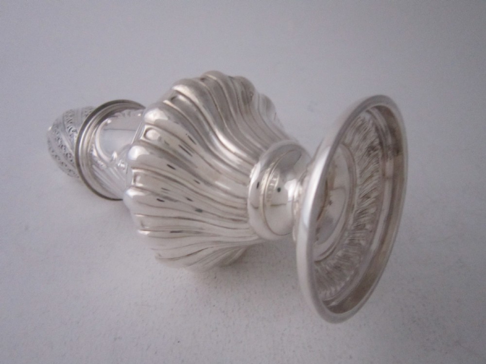 A Victorian sterling silver sugar caster with a spiralled finial, a hand-pierced cap, and a decorated baluster-shaped body. View VII