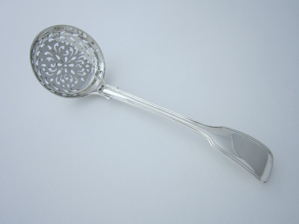 A Victorian sterling silver sifter spoon featuring a pierced scrolled bowl design and a Fiddle and Thread pattern handle.