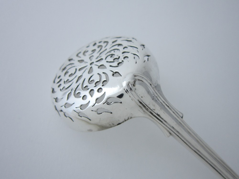 A Victorian sterling silver sifter spoon featuring a pierced scrolled bowl design and a Fiddle and Thread pattern handle. View IV