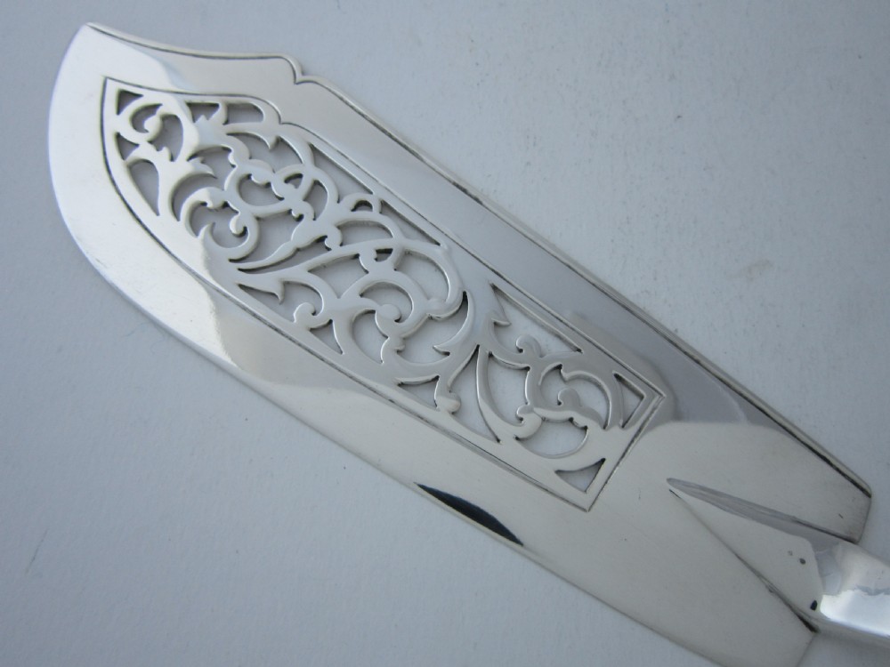 A pair of Victorian sterling silver fish servers featuring a pierced scrollwork knife blade and a four-tine fork with fiddle pattern handles. View III