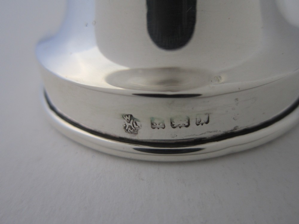 An Edwardian sterling silver and ribbed clear glass pepper grinder with hallmarked silver mounts on the top and base. View VI