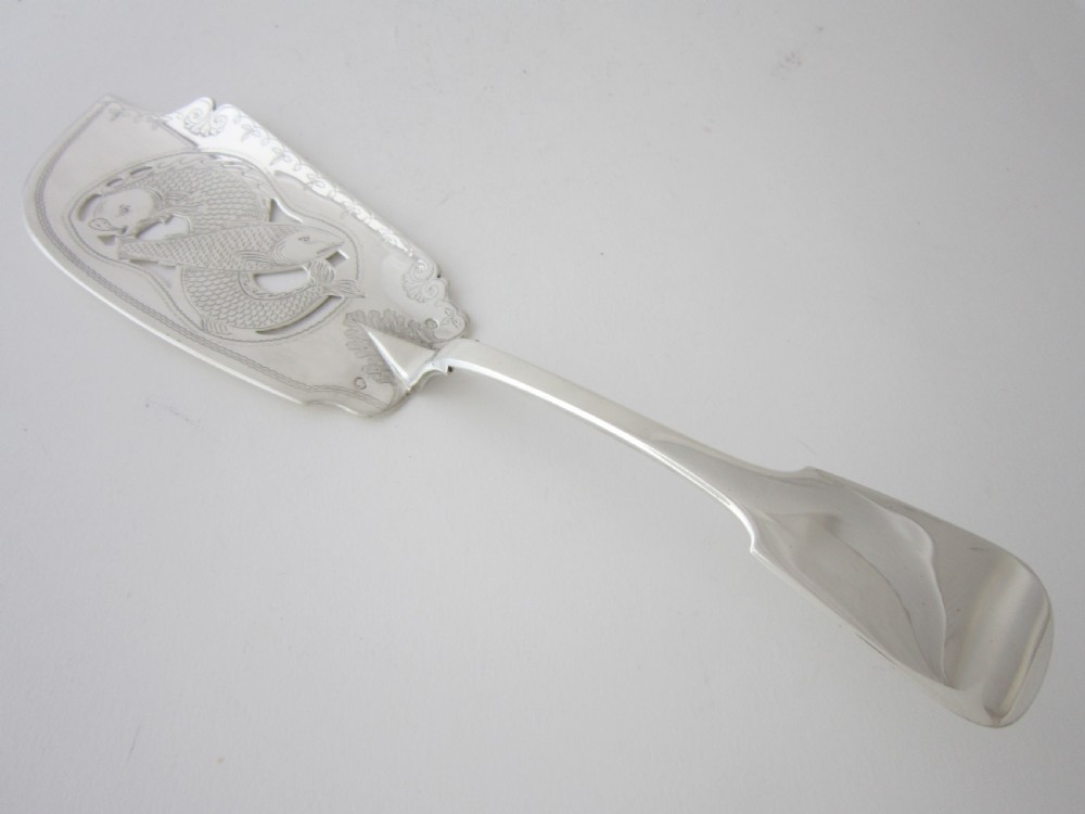 An Irish George IV sterling silver fish slice with a pierced fish motif on the blade and a fiddle pattern handle.