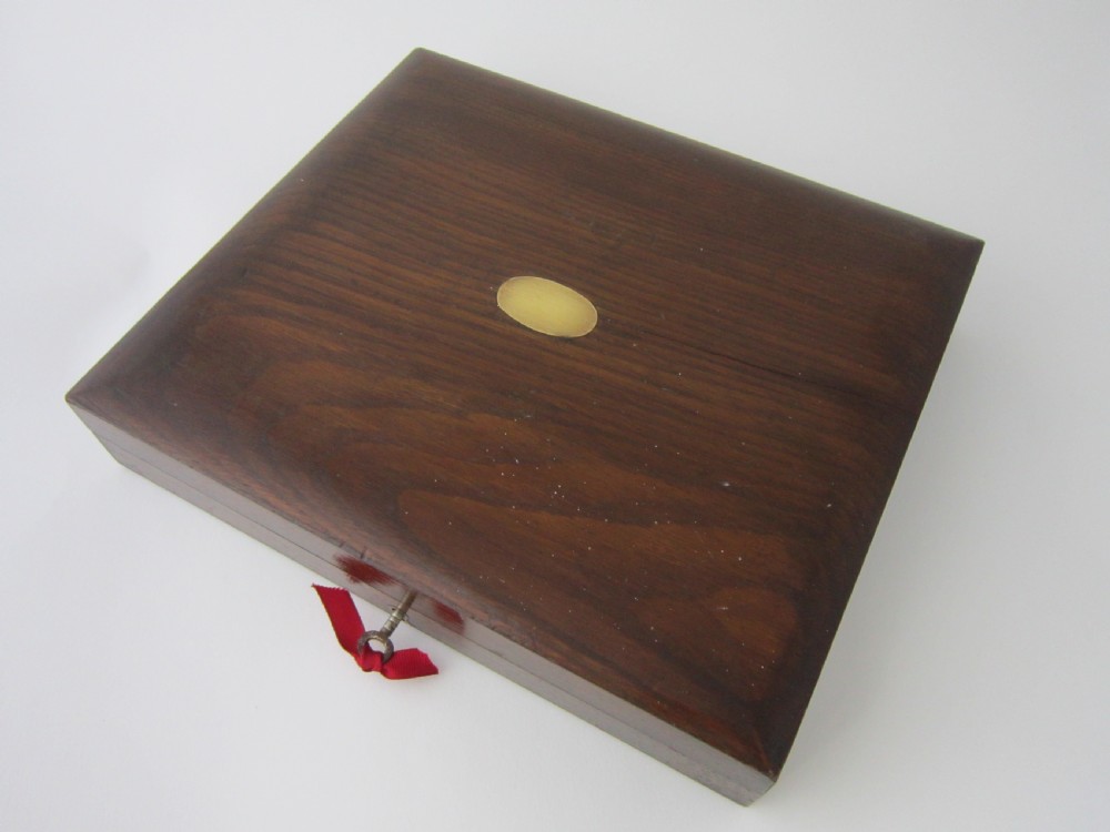An open fitted wooden canteen lined with green velvet, containing a set of sterling silver dessert knives and forks with carved mother-of-pearl handles. View XII