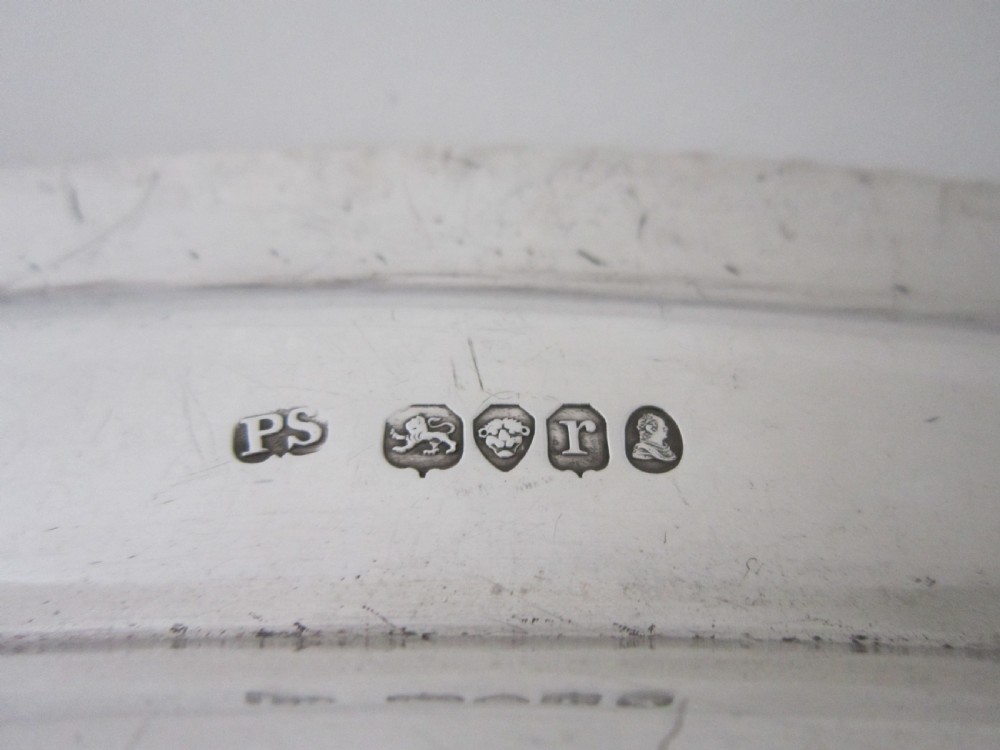 An oval William IV sterling silver meat platter featuring a gadrooned rim and an engraved heraldic coat of arms. View VI