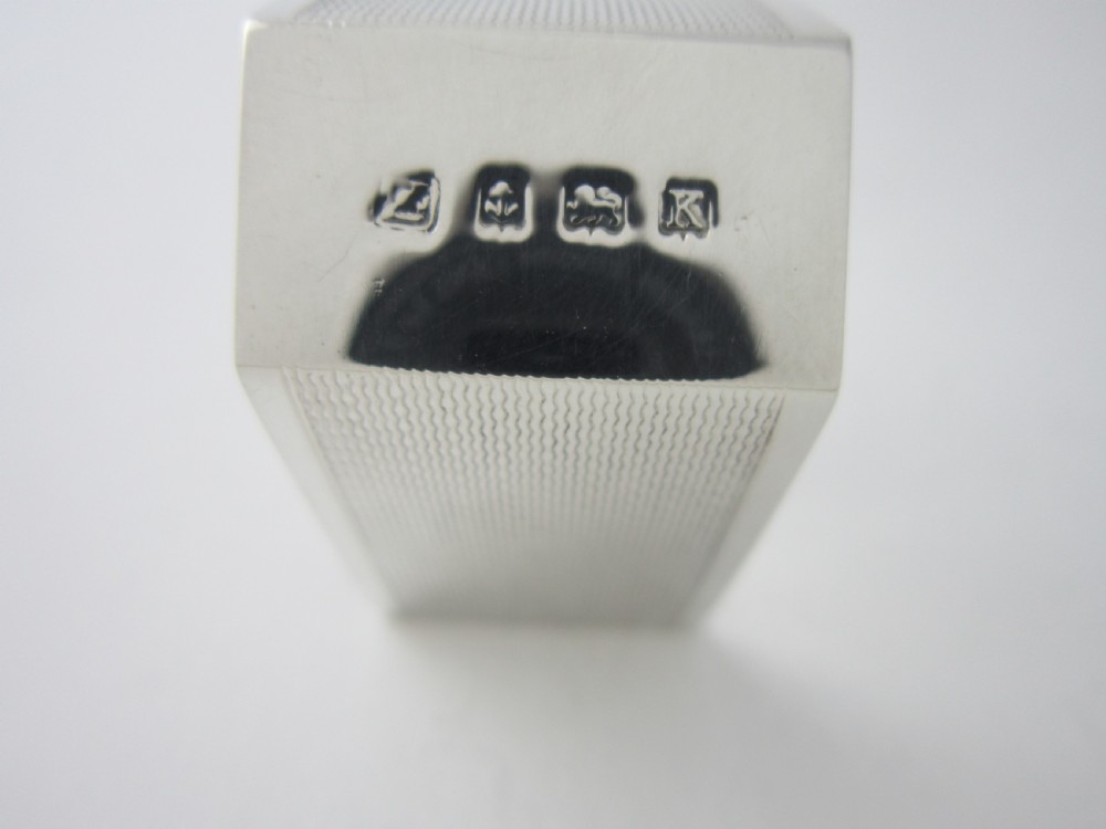 A pair of faceted sterling silver Art Deco napkin rings with subtle engine-turned patterning, presented in a fitted black display box with a cream satin lining. View VIII