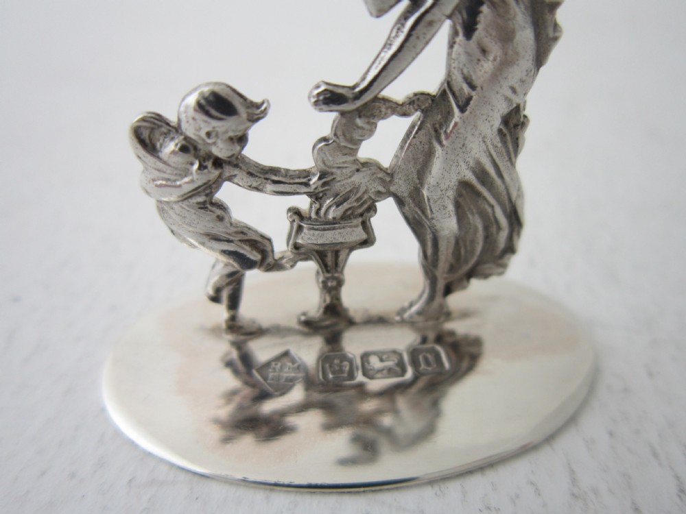 A pair of Edwardian sterling silver place card holders depicting classical figures and cherubs on circular hallmarked bases. View II
