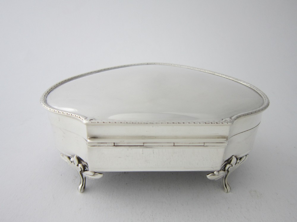 An antique George V sterling silver trinket box with a smooth shaped hinged lid, beaded trim, and four raised feet. View IV