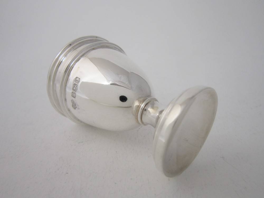 A George V sterling silver egg cruet set featuring four egg cups and matching spoons arranged on an oval silver tray with a central loop handle. View VIII