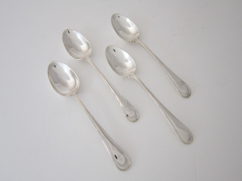 A George V sterling silver egg cruet set featuring four egg cups and matching spoons arranged on an oval silver tray with a central loop handle. View IX