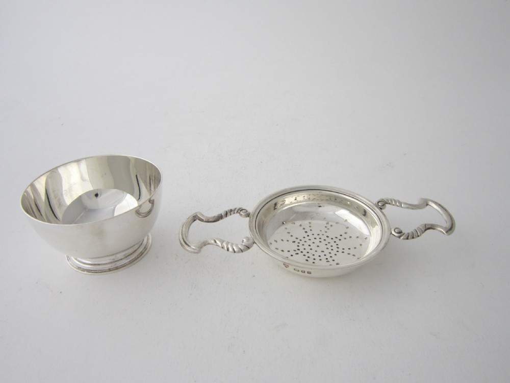 A solid sterling silver double-handled tea strainer with a pierced star bowl pattern and scrolled side handles. View II