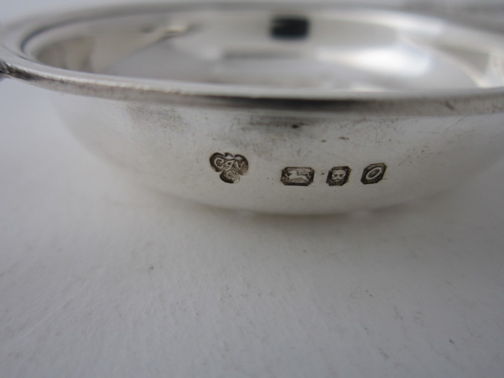 A solid sterling silver double-handled tea strainer with a pierced star bowl pattern and scrolled side handles. View V