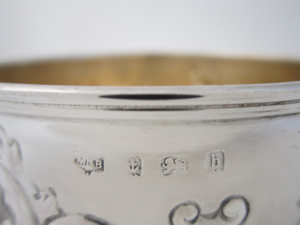 An Edwardian sterling silver bowl featuring repousse scroll motifs, a gilded interior, a raised foot rim, and visible English hallmarks. View VII