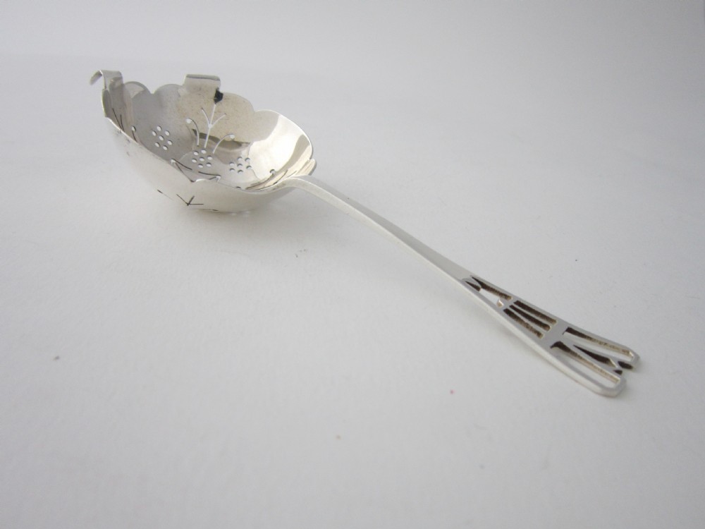 A sterling silver tea strainer featuring a pierced bowl with geometric patterns and an openwork handle. View II