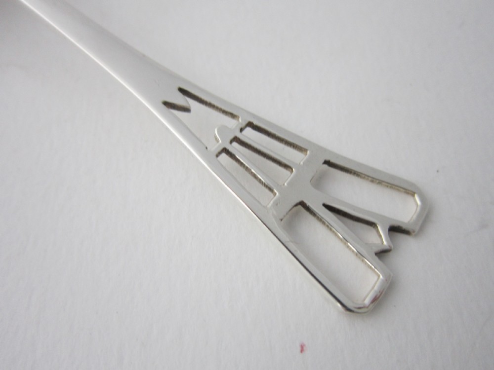 A sterling silver tea strainer featuring a pierced bowl with geometric patterns and an openwork handle. View IV