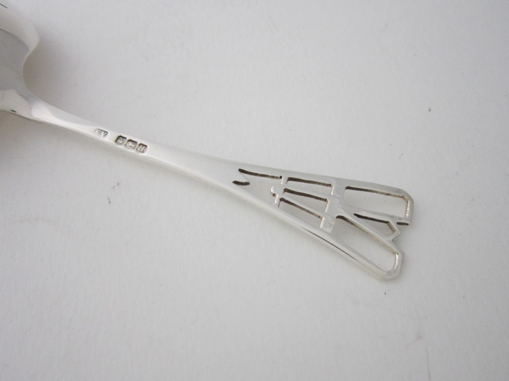 A sterling silver tea strainer featuring a pierced bowl with geometric patterns and an openwork handle. View VII
