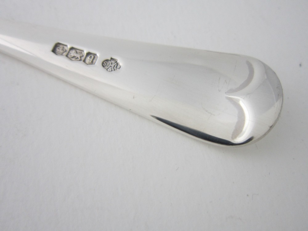 An antique sterling silver Stilton scoop featuring a curved spade-shaped blade and a smooth Old English pattern handle. View VI