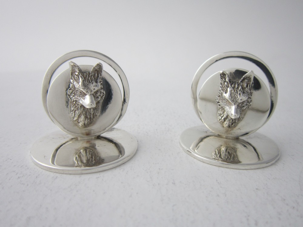 A pair of sterling silver place card holders featuring sculpted fox heads mounted on circular silver bases. View II