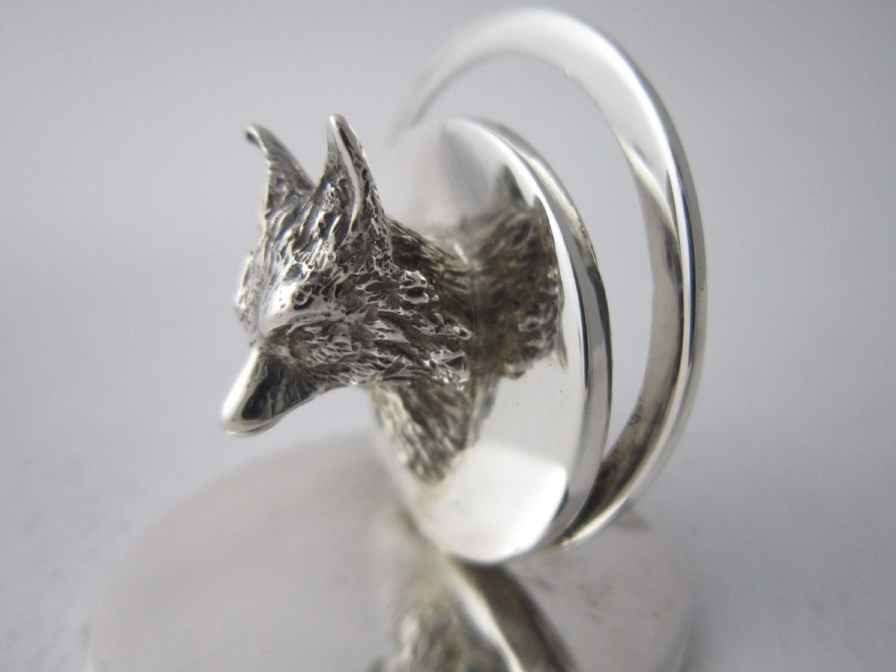A pair of sterling silver place card holders featuring sculpted fox heads mounted on circular silver bases. View V