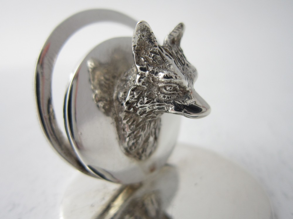 A pair of sterling silver place card holders featuring sculpted fox heads mounted on circular silver bases. View VI