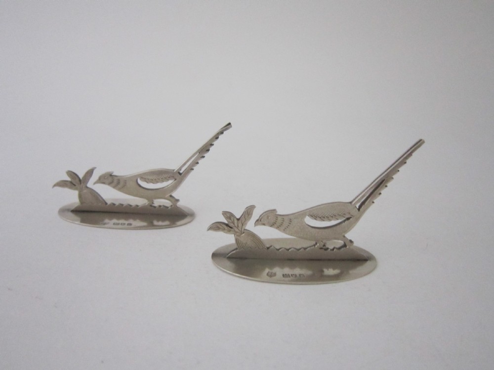 A pair of hallmarked sterling silver menu card holders featuring silhouetted pheasants set on oval bases. View II
