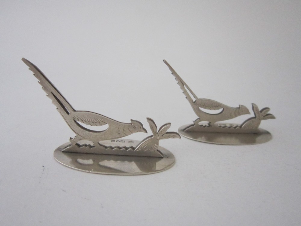 A pair of hallmarked sterling silver menu card holders featuring silhouetted pheasants set on oval bases. View III