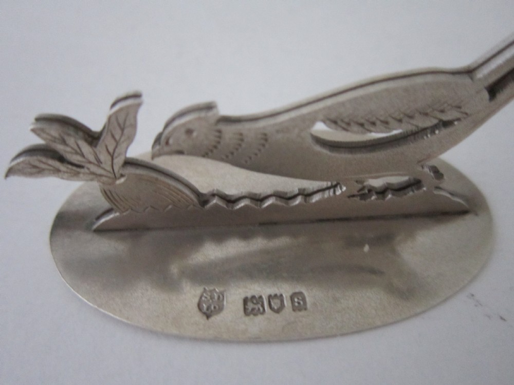 A pair of hallmarked sterling silver menu card holders featuring silhouetted pheasants set on oval bases. View VI
