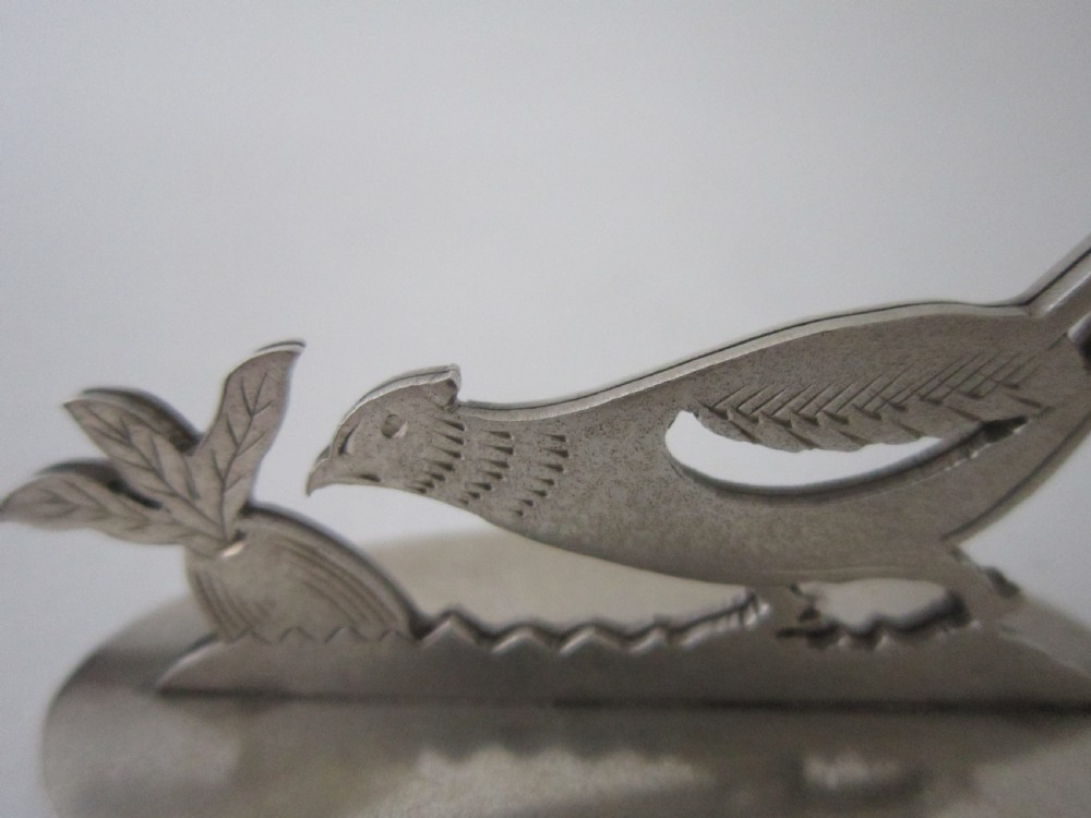 A pair of hallmarked sterling silver menu card holders featuring silhouetted pheasants set on oval bases. View VII