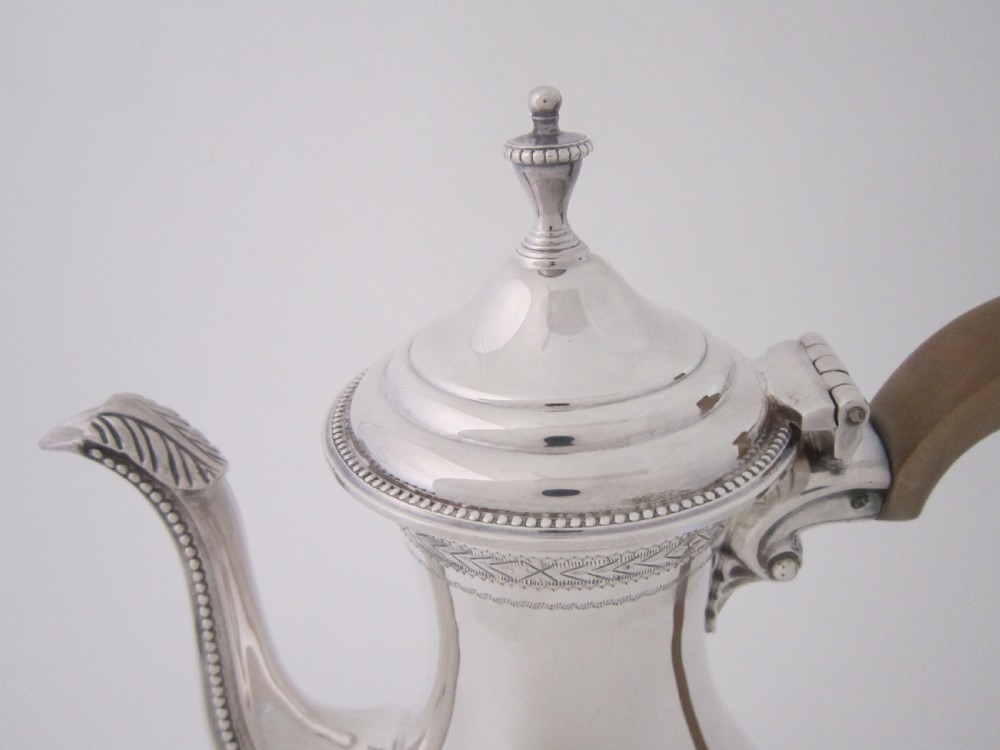 A five-piece sterling silver tea and coffee set featuring carved wooden handles, engraved oval cartouches, a teapot with stand, coffee pot, cream jug, and sugar basket. View III