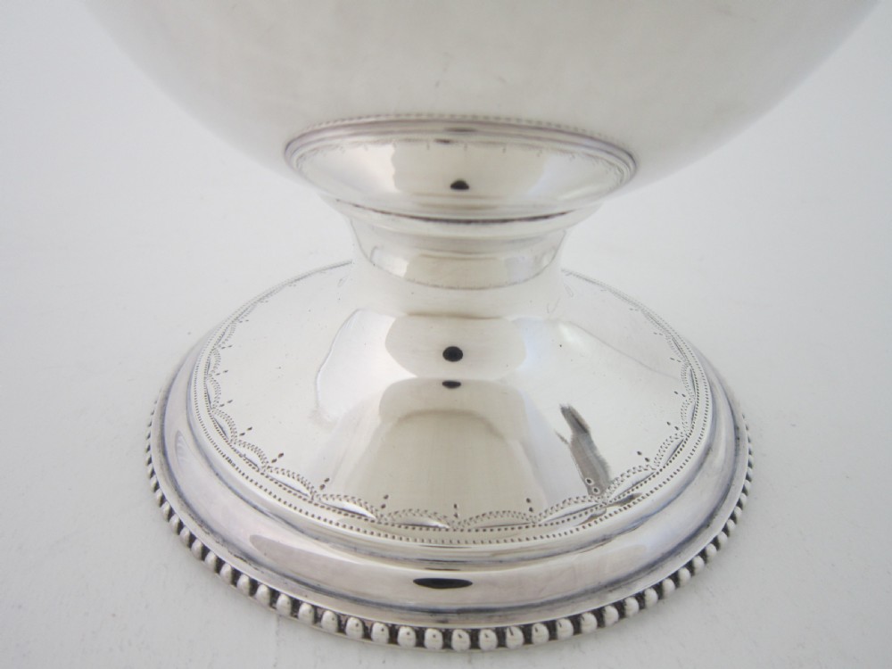 A five-piece sterling silver tea and coffee set featuring carved wooden handles, engraved oval cartouches, a teapot with stand, coffee pot, cream jug, and sugar basket. View V