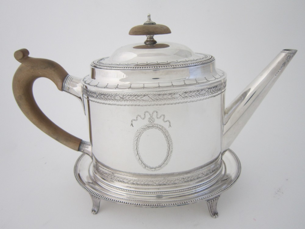 A five-piece sterling silver tea and coffee set featuring carved wooden handles, engraved oval cartouches, a teapot with stand, coffee pot, cream jug, and sugar basket. View VII