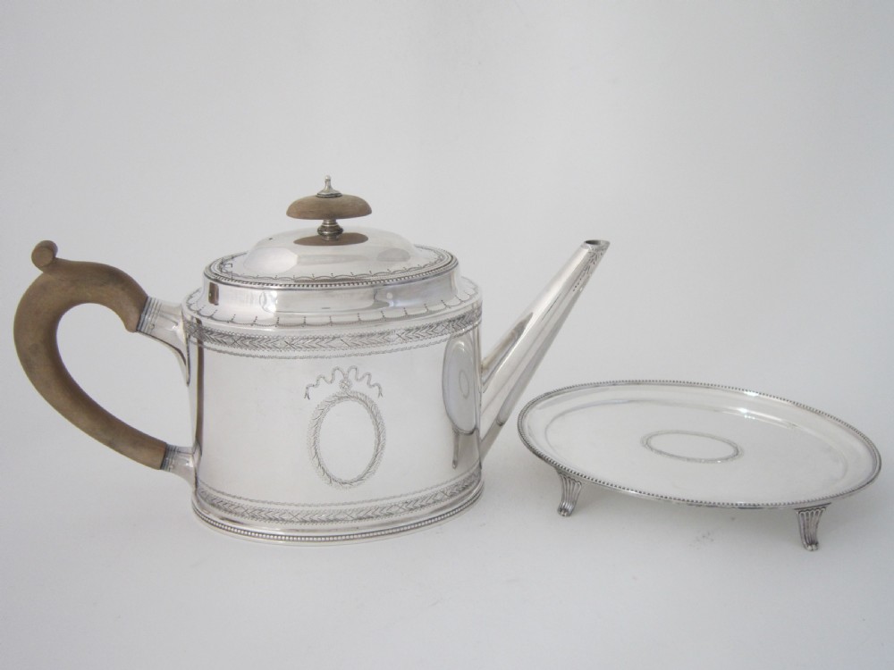 A five-piece sterling silver tea and coffee set featuring carved wooden handles, engraved oval cartouches, a teapot with stand, coffee pot, cream jug, and sugar basket. View VIII
