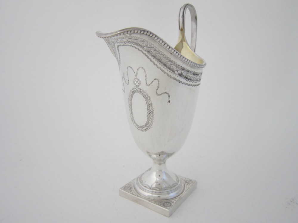 A five-piece sterling silver tea and coffee set featuring carved wooden handles, engraved oval cartouches, a teapot with stand, coffee pot, cream jug, and sugar basket. View XII