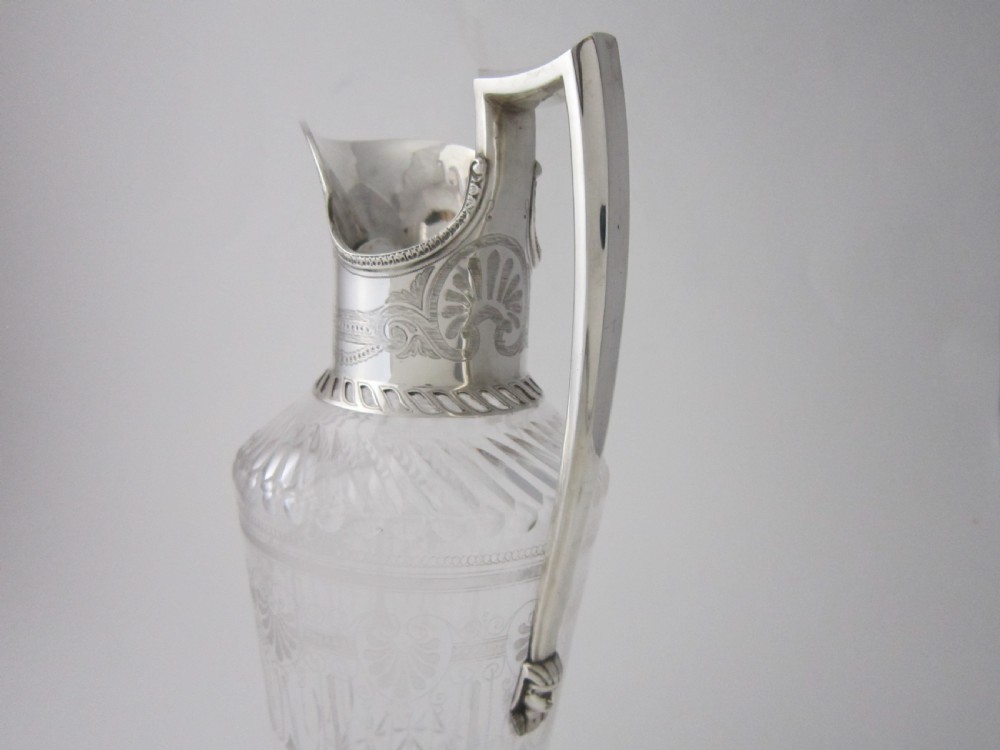 An antique Victorian claret jug featuring a clear etched glass body with cut geometric patterns and an engraved sterling silver collar and handle. View III