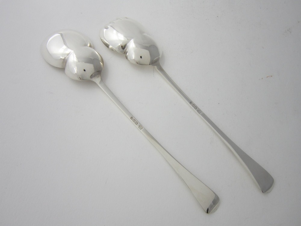A pair of Edwardian sterling silver salad servers with chased foliate handles and shaped lobed bowls, dating to 1903. View II