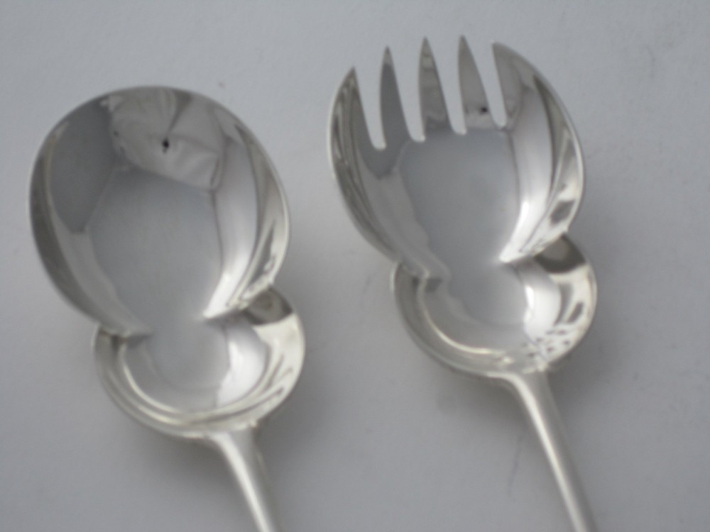 A pair of Edwardian sterling silver salad servers with chased foliate handles and shaped lobed bowls, dating to 1903. View III