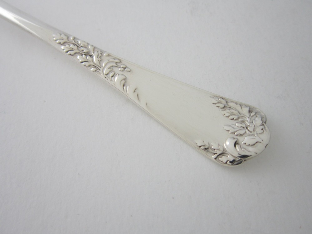 A pair of Edwardian sterling silver salad servers with chased foliate handles and shaped lobed bowls, dating to 1903. View IV