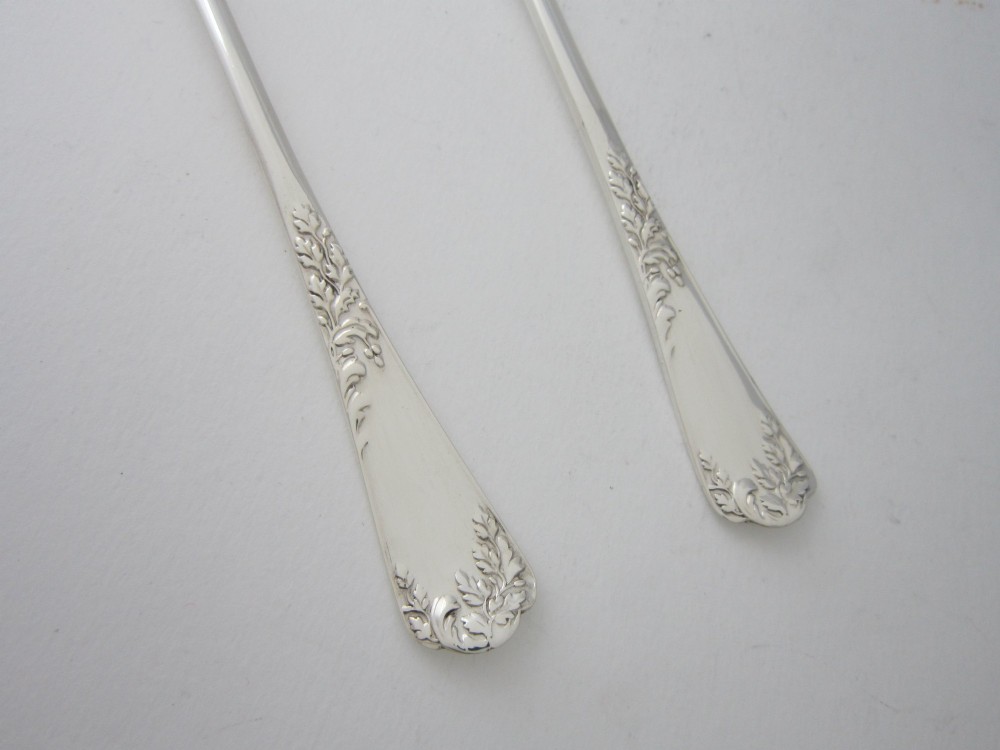 A pair of Edwardian sterling silver salad servers with chased foliate handles and shaped lobed bowls, dating to 1903. View V